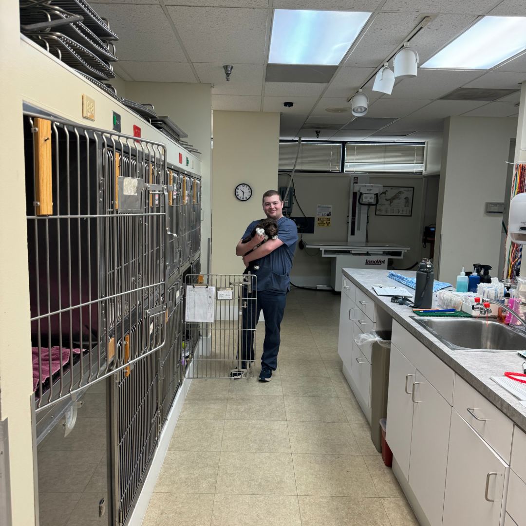 A man and a dog next to a cage