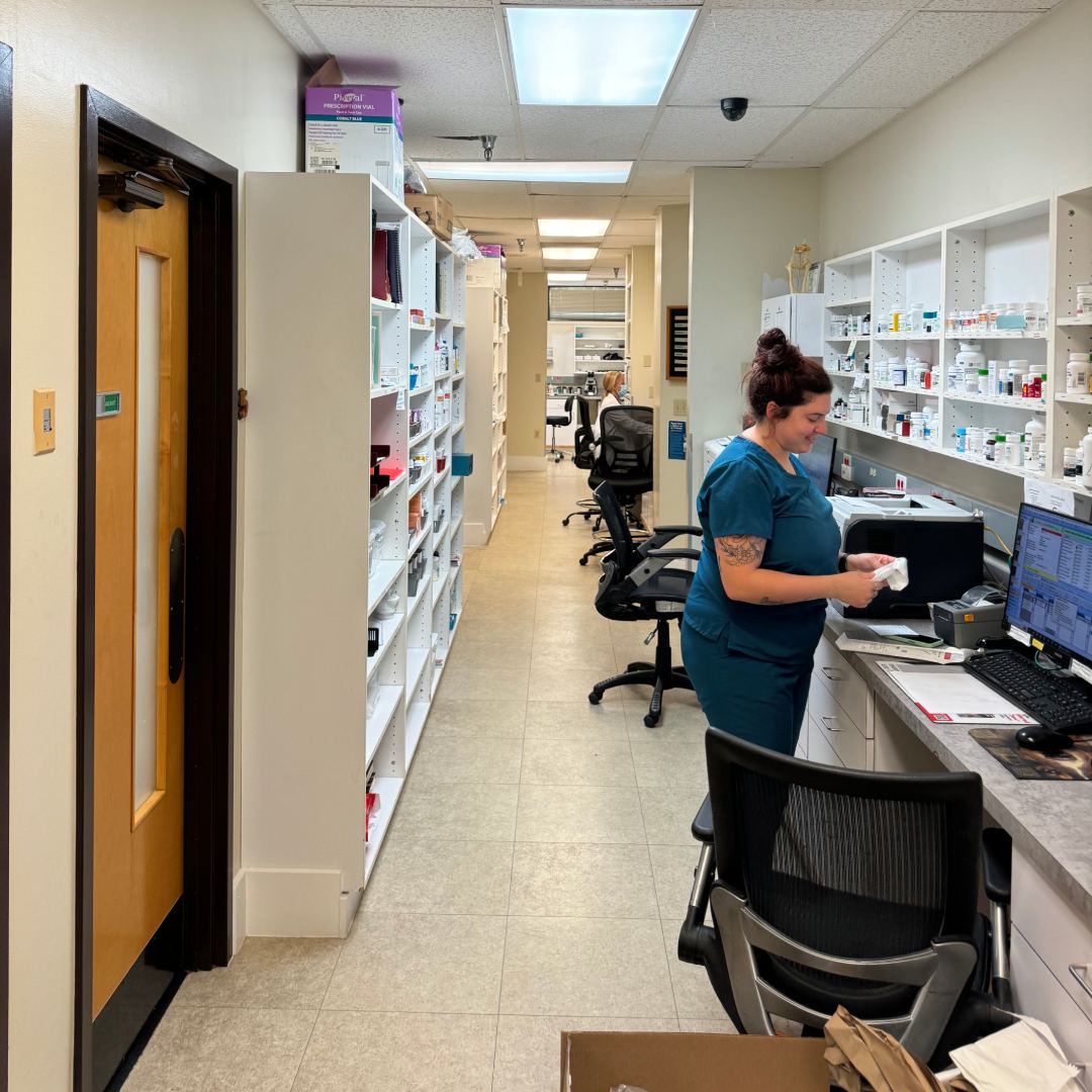 A pharmacy tech providing service at the pharmacy counter